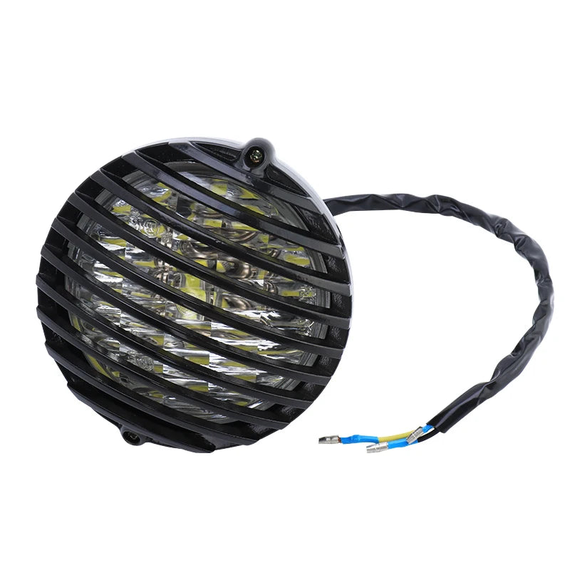 Grille de protection métallique noire posée sur un phare rond de moto rétro - vue 7