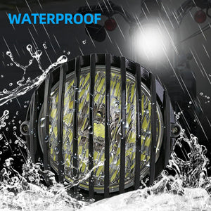 Grille de protection métallique noire posée sur un phare rond de moto rétro - vue 3